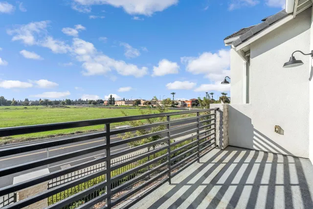 a view of a balcony with wooden floor & fence