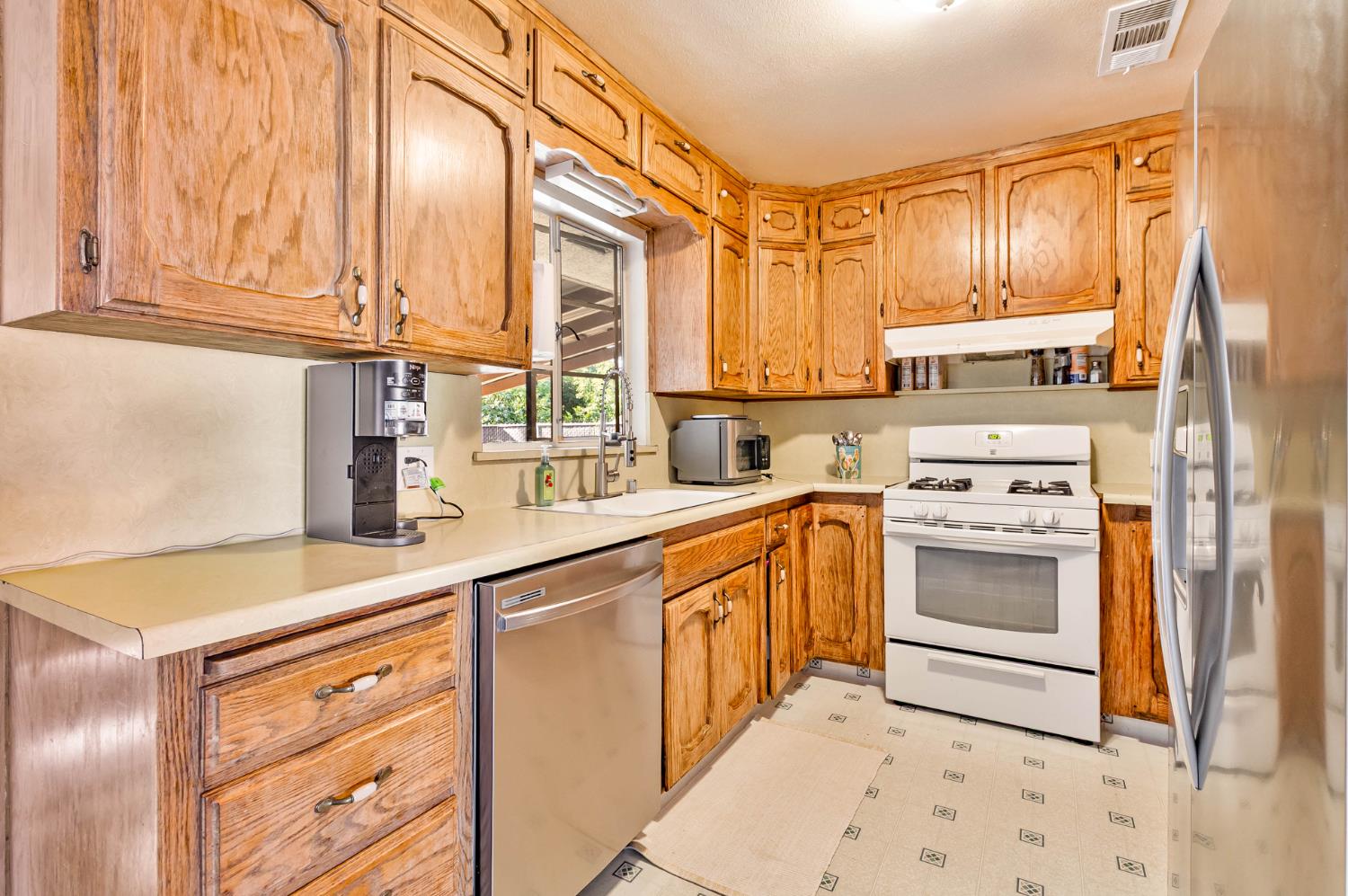 3852 East Washington Avenue Fresno, CA 93702 - Photo 7 of 30 a kitchen with stainless steel appliances granite countertop a sink and cabinets with wooden floor