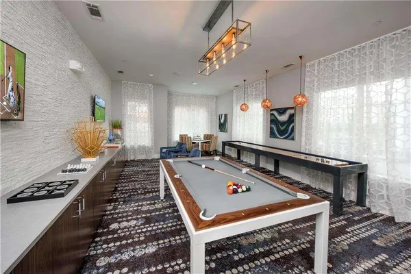 a room with pool table and windows