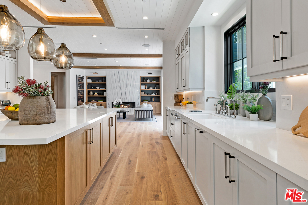 6310 Mirror Drive Los Angeles, CA 90068 - Photo 17 of 49 a large white kitchen with lots of counter space and chandelier