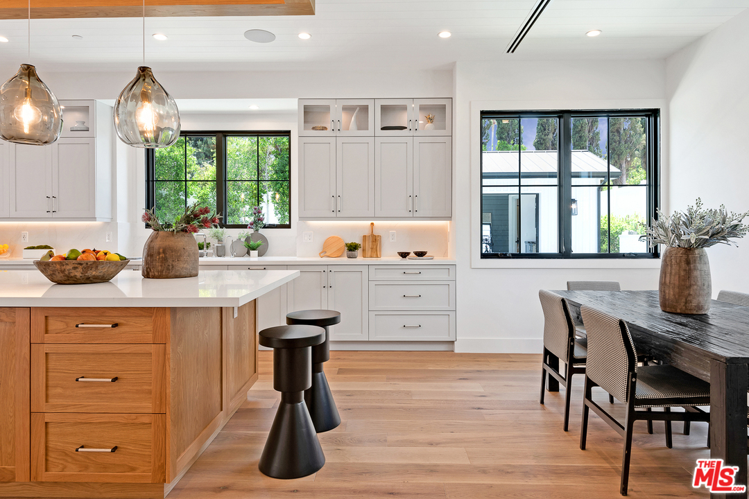 6310 Mirror Drive Los Angeles, CA 90068 - Photo 18 of 49 a kitchen with a table chairs refrigerator and cabinets