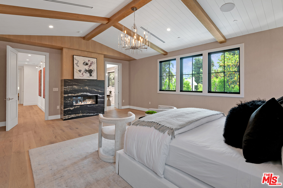 6310 Mirror Drive Los Angeles, CA 90068 - Photo 27 of 49 a bedroom with a bed a fireplace and a large window