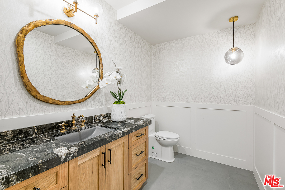 6310 Mirror Drive Los Angeles, CA 90068 - Photo 39 of 49 a bathroom with a granite countertop sink and a mirror