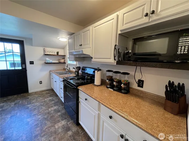 a kitchen with cabinets and a stove top oven