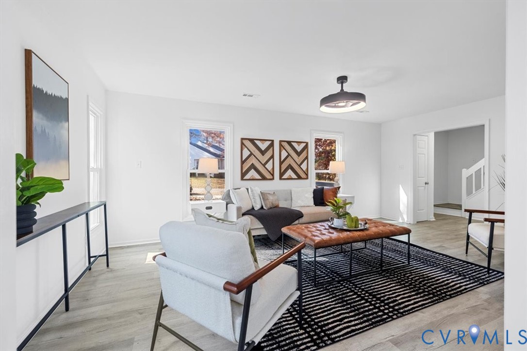 Living area with light wood-type flooring and stai