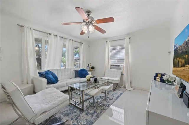 a living room with furniture a ceiling fan and a window