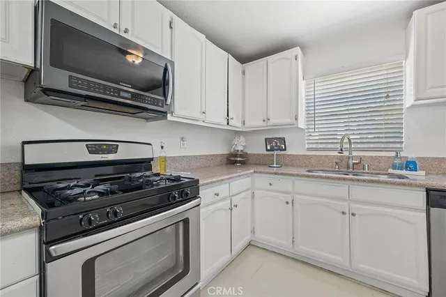 a kitchen with cabinets stainless steel appliances and a sink