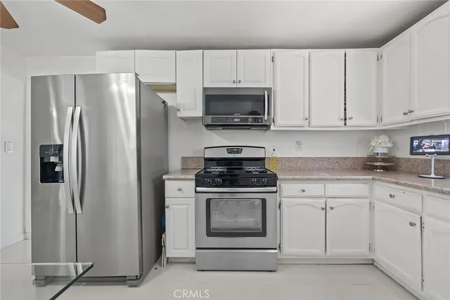 a kitchen with white cabinets and stainless steel appliances