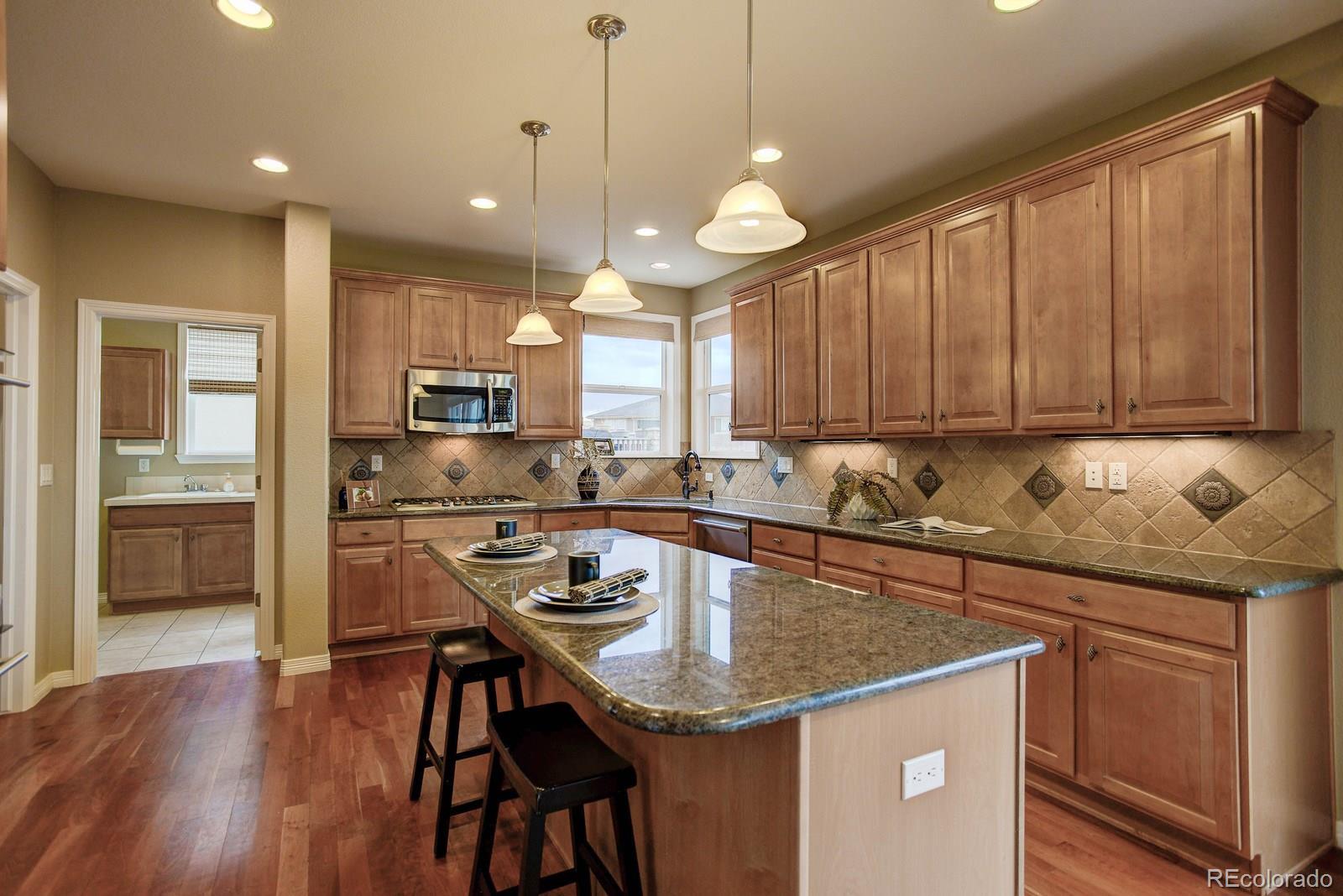 10879 Glengate Circle Highlands Ranch, CO 80130 - Photo 12 of 35 a kitchen with a table chairs microwave and cabinets