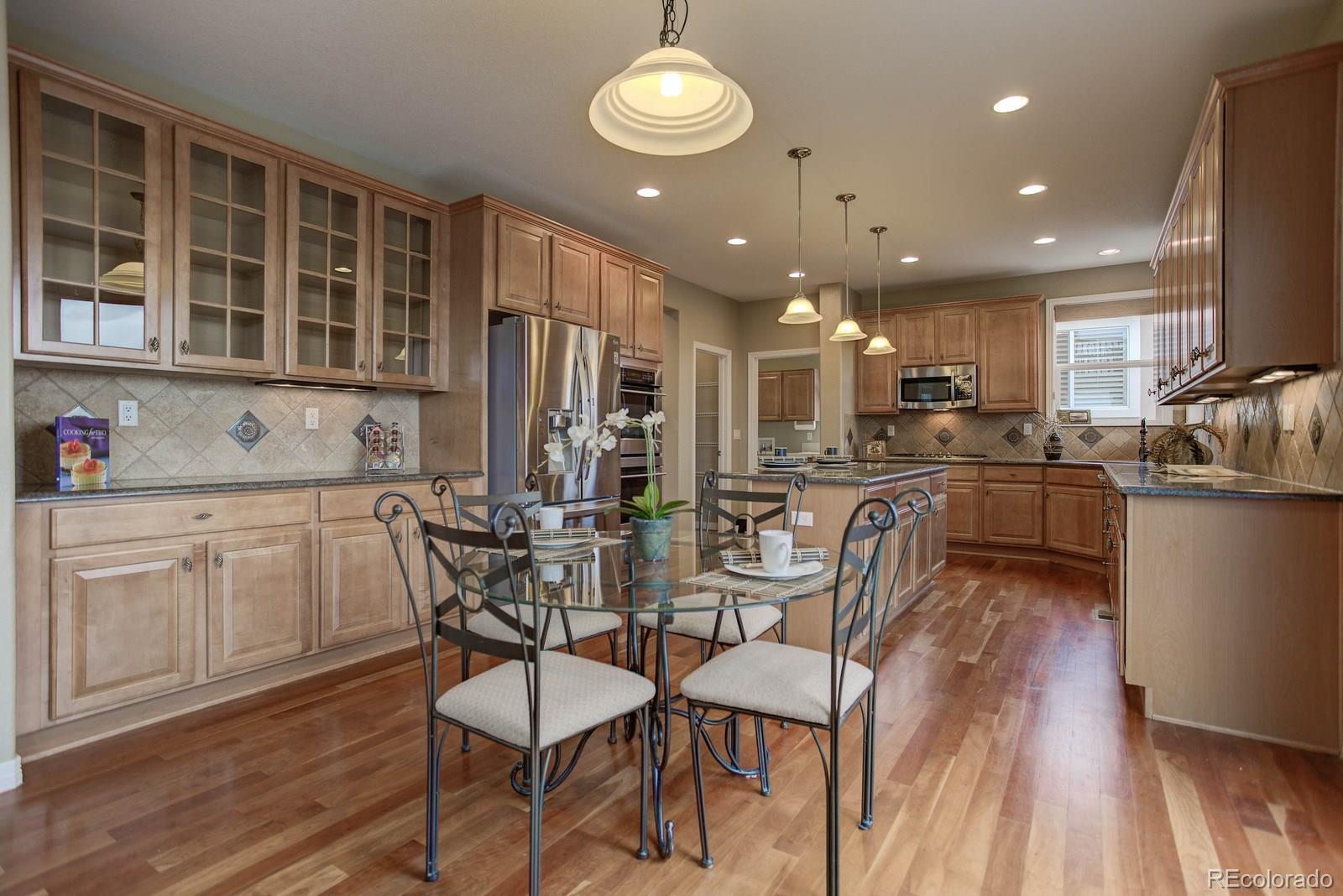 10879 Glengate Circle Highlands Ranch, CO 80130 - Photo 14 of 35 a view of a dining room with furniture and wooden floor