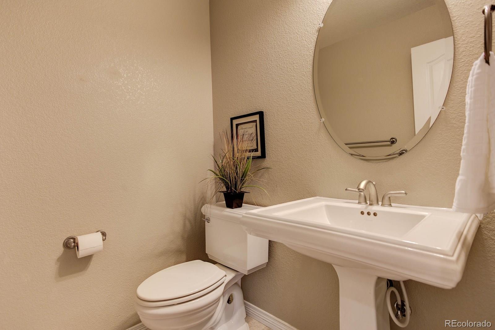 10879 Glengate Circle Highlands Ranch, CO 80130 - Photo 18 of 35 a bathroom with a toilet a sink and mirror