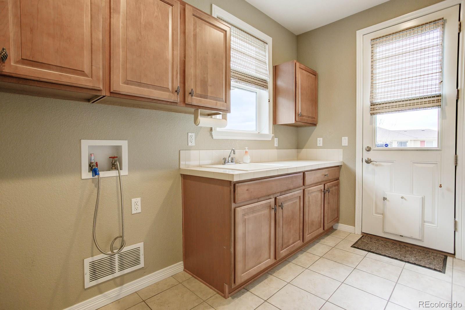 10879 Glengate Circle Highlands Ranch, CO 80130 - Photo 19 of 35 a utility room with a sink dryer and washer