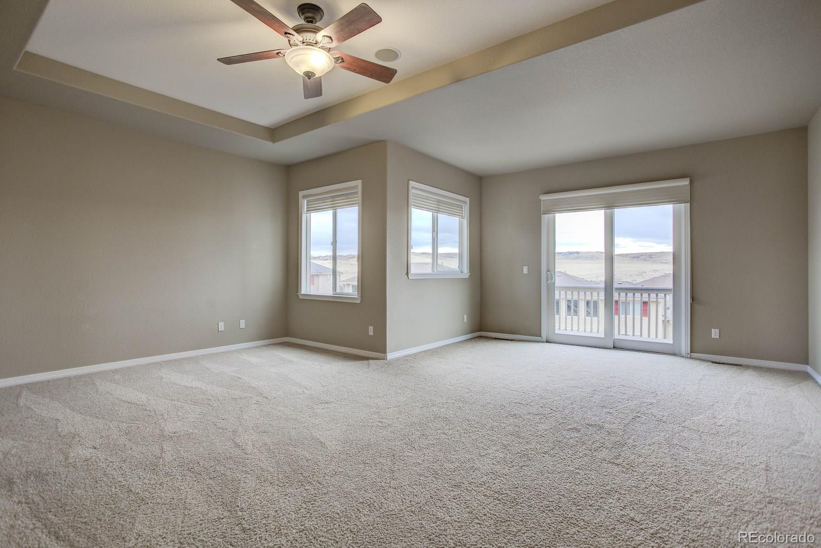 10879 Glengate Circle Highlands Ranch, CO 80130 - Photo 21 of 35 a view of an empty room with window and chandelier fan