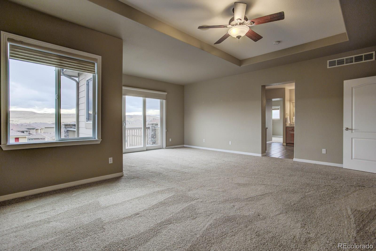 10879 Glengate Circle Highlands Ranch, CO 80130 - Photo 23 of 35 a view of an empty room with window and chandelier fan