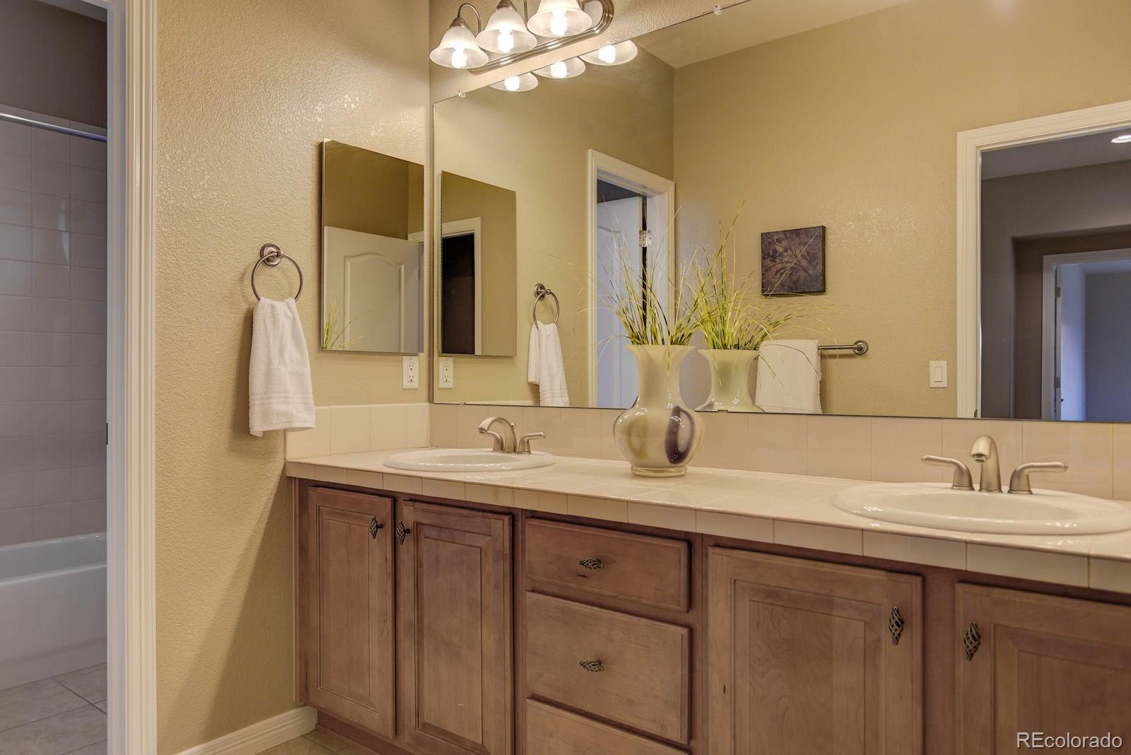 10879 Glengate Circle Highlands Ranch, CO 80130 - Photo 31 of 35 a bathroom with a double vanity sink and a mirror
