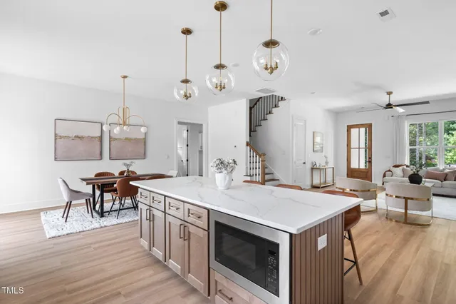 a open kitchen with stainless steel appliances granite countertop a stove and a wooden floors