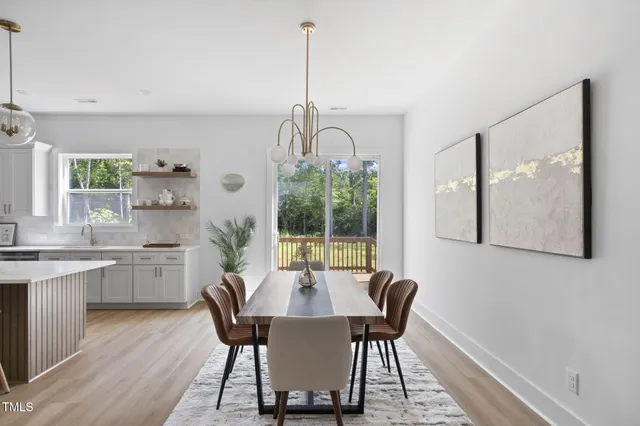 a dining room with wooden floor a chandelier a wooden table and chairs