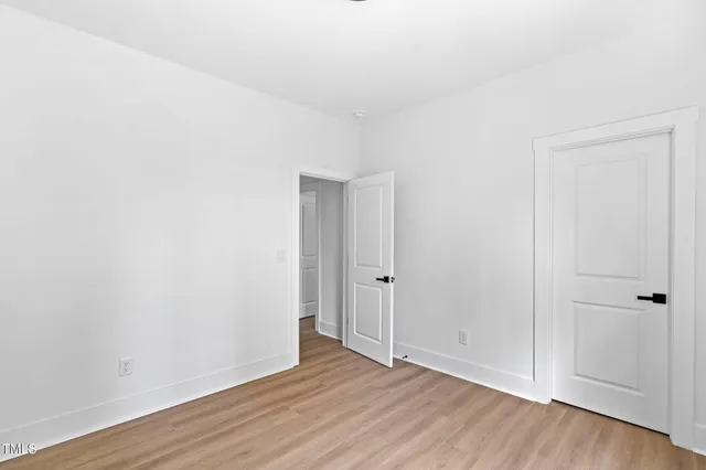 a view of an empty room with wooden floor