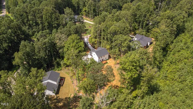 a aerial view of a house with a yard and trees