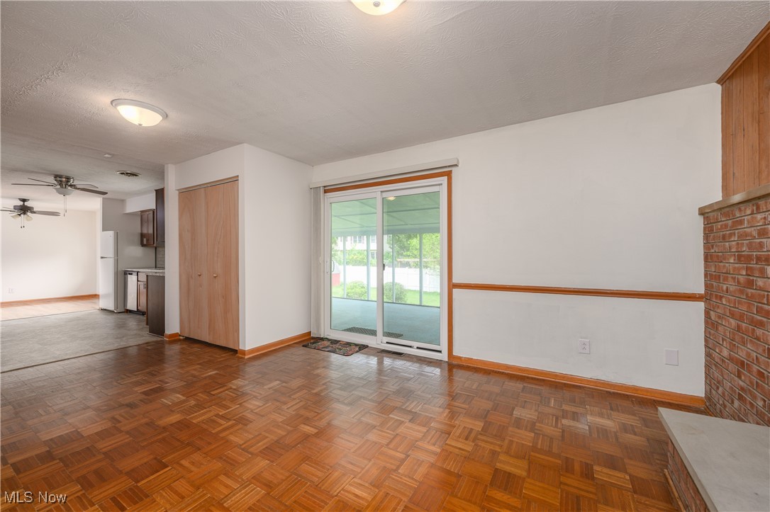 2783 Shellhart Road Barberton, OH 44203 - Photo 9 of 24 Unfurnished living room with ceiling fan and a textured ceiling