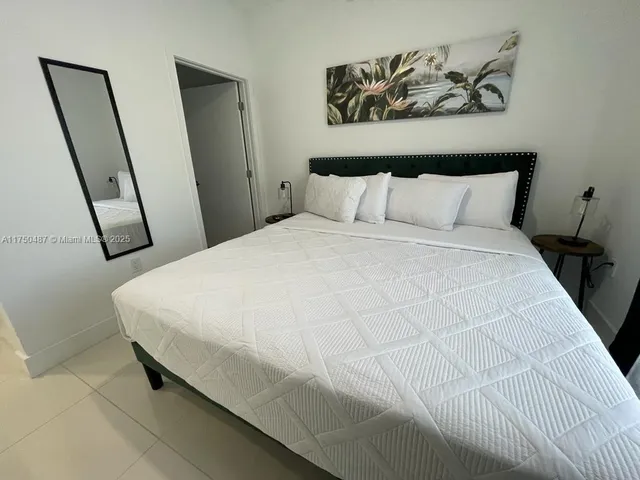 a large bed sitting in a bedroom next to a window