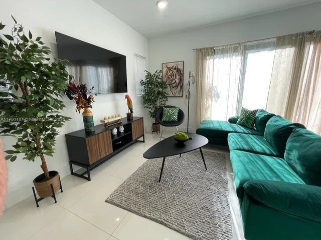 a living room with furniture and a potted plant
