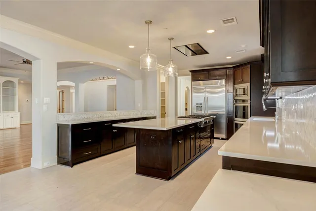 a kitchen with stainless steel appliances granite countertop a stove a sink and a microwave
