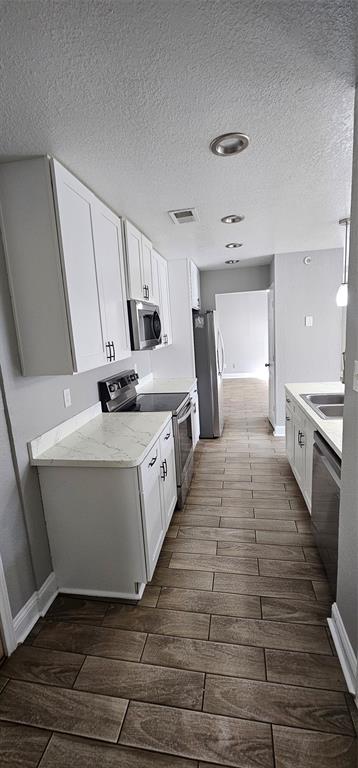 433 Ard Road Seagoville, TX 75159 - Photo 5 of 16 a large white kitchen with wooden floors and wide window
