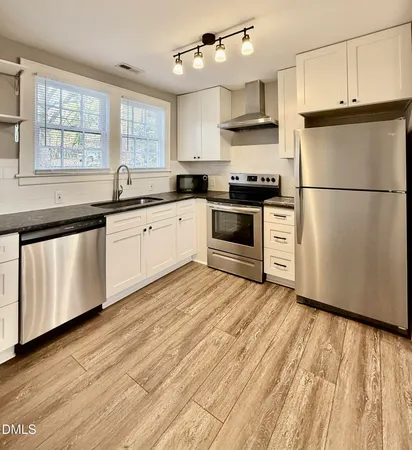 a kitchen with granite countertop a refrigerator sink and cabinets