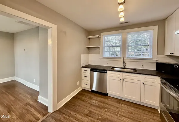 a kitchen with stainless steel appliances granite countertop a sink and wooden cabinets