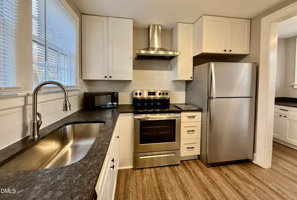 a kitchen with stainless steel appliances granite countertop a refrigerator sink and stove