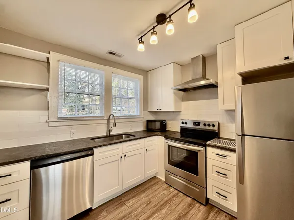 a kitchen with stainless steel appliances a stove sink and refrigerator