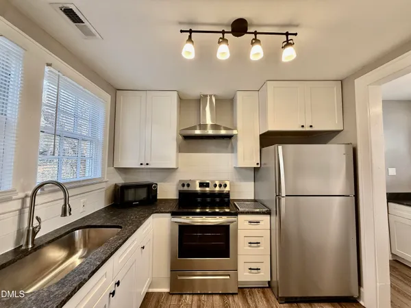 a kitchen with stainless steel appliances a refrigerator sink and cabinets