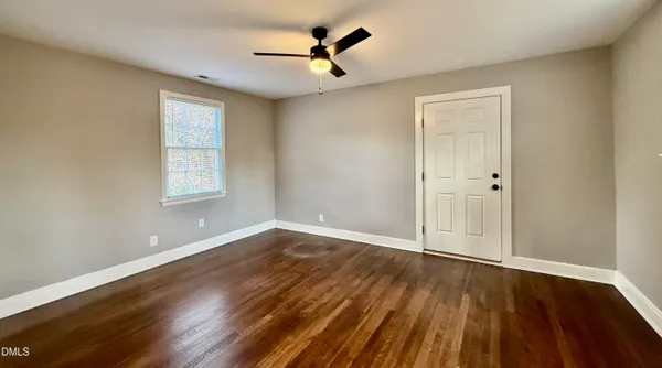 wooden floor in an empty room with a window