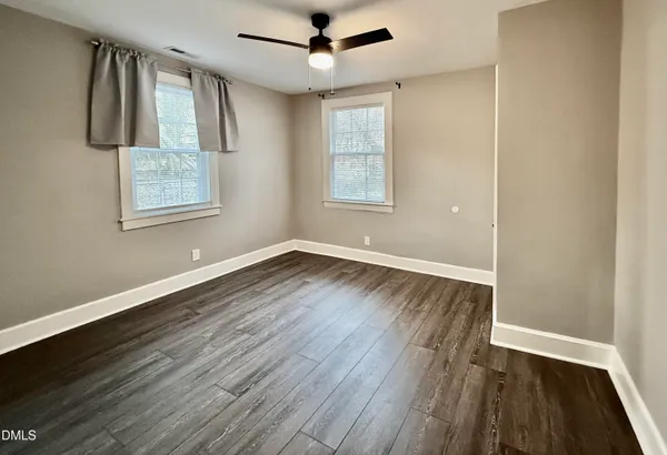 a view of empty room with wooden floor