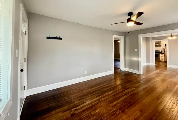a view of empty room with wooden floor