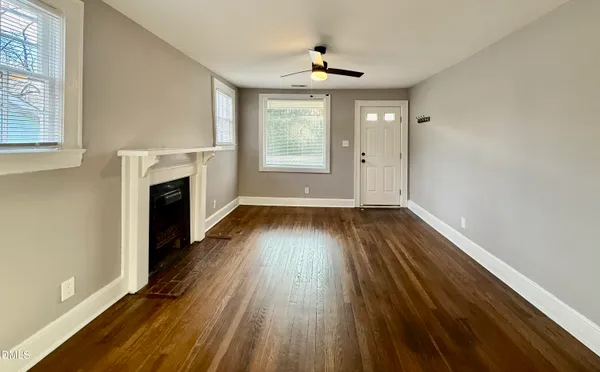 a view of empty room with wooden floor and fireplace