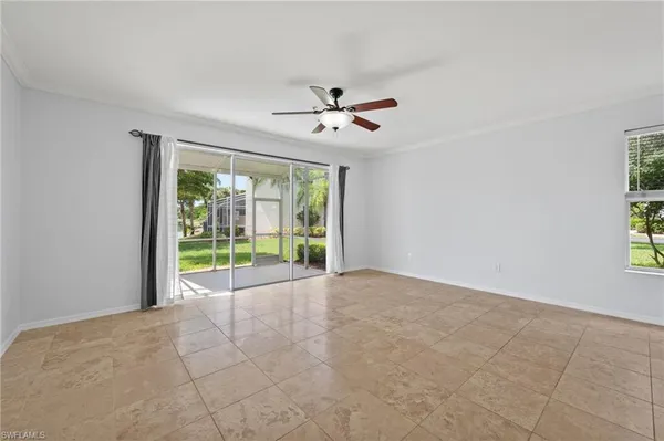 a view of an empty room with a ceiling fan and a window