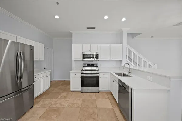 a kitchen with granite countertop a sink stove and refrigerator