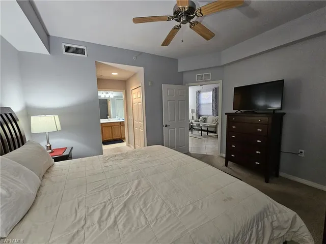 a bedroom with a bed and a flat tv screen on dresser