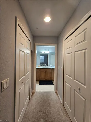 a view of an empty room and a kitchen