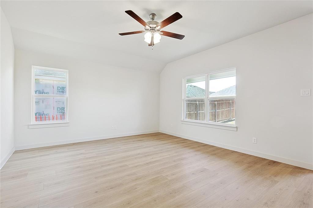 1759 Gleasondale Place Forney, TX 75126 - Photo 9 of 25 Spare room featuring light wood-style floors, lofted ceiling, and a ceiling fan