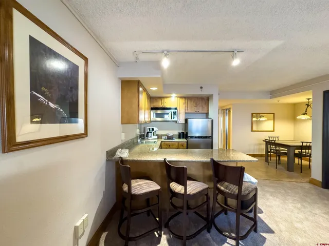 a view of a dining room with a table and chairs