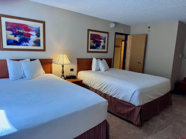 a bedroom with bed and paintings on the wall