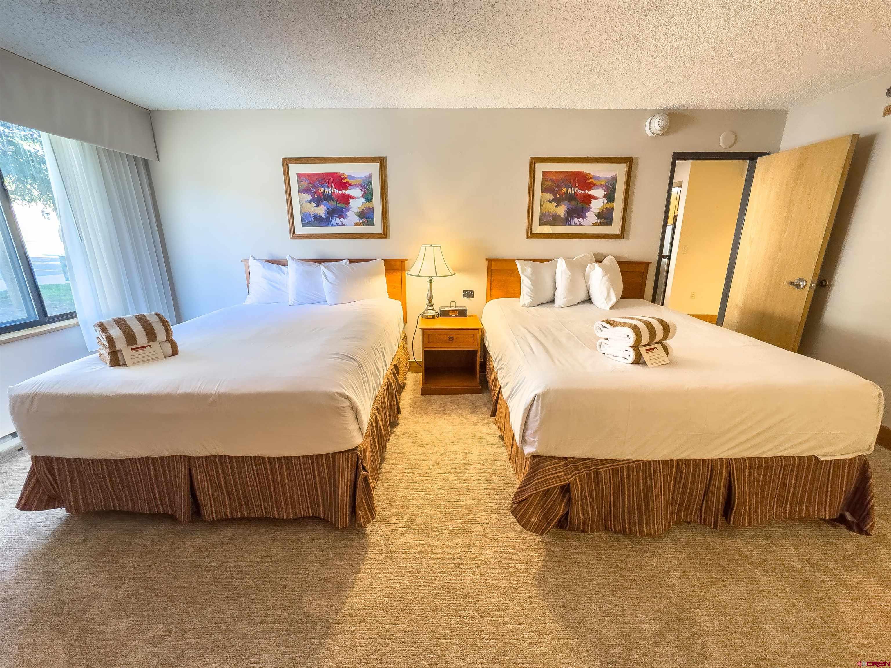 6 Emmons Road, Unit 125 Crested Butte, CO 81225 - Photo 25 of 42 a bedroom with two bed and a mirror