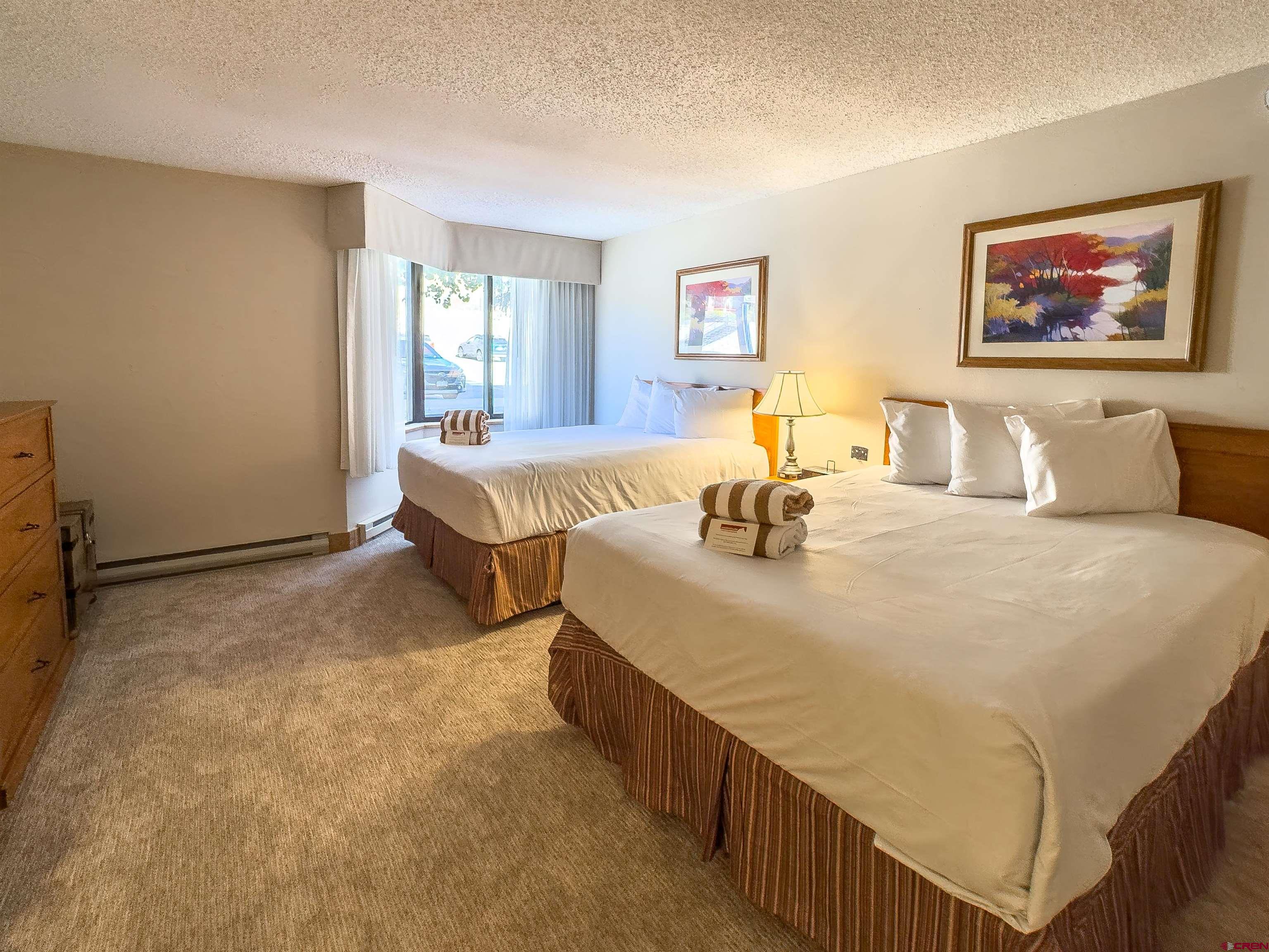 6 Emmons Road, Unit 125 Crested Butte, CO 81225 - Photo 29 of 42 a bedroom with double bed and paintings on the wall