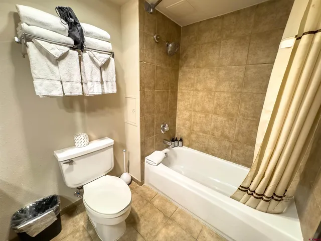 a bathroom with a granite countertop toilet a sink and a mirror