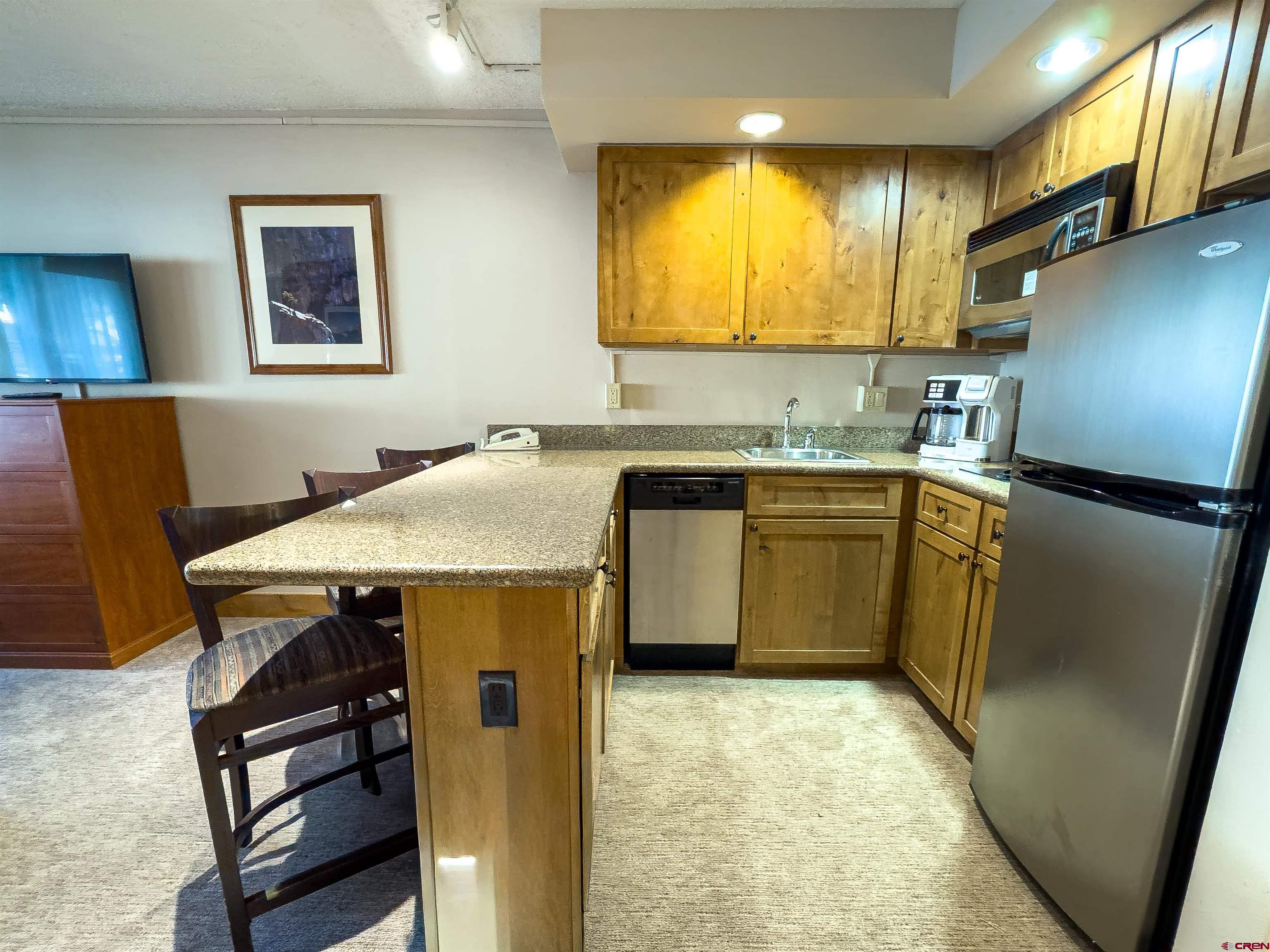 6 Emmons Road, Unit 125 Crested Butte, CO 81225 - Photo 5 of 42 a kitchen with stainless steel appliances granite countertop a sink stove and refrigerator