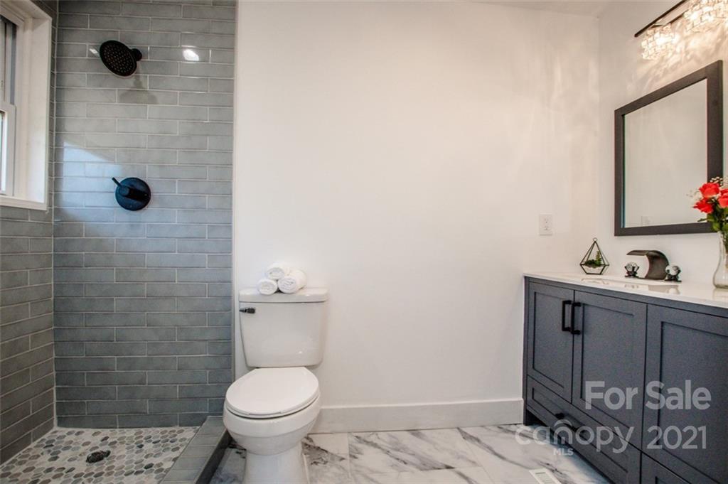3748 Woodleaf Road Salisbury, NC 28147 - Photo 14 of 31 a bathroom with a toilet sink a shower and mirror