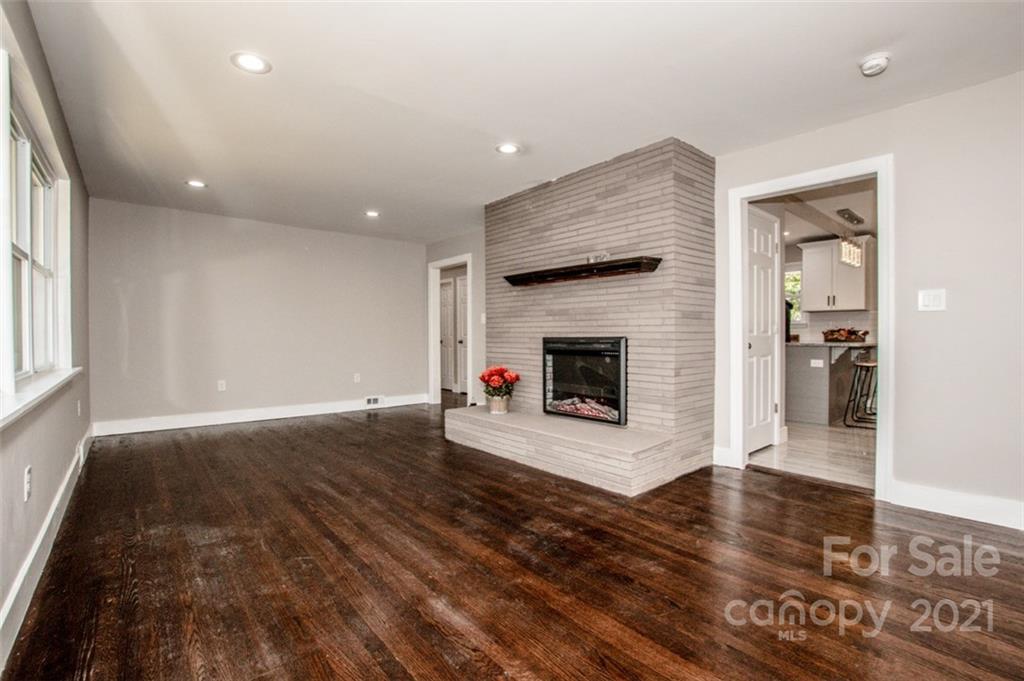 3748 Woodleaf Road Salisbury, NC 28147 - Photo 19 of 31 an empty room with wooden floor and fireplace